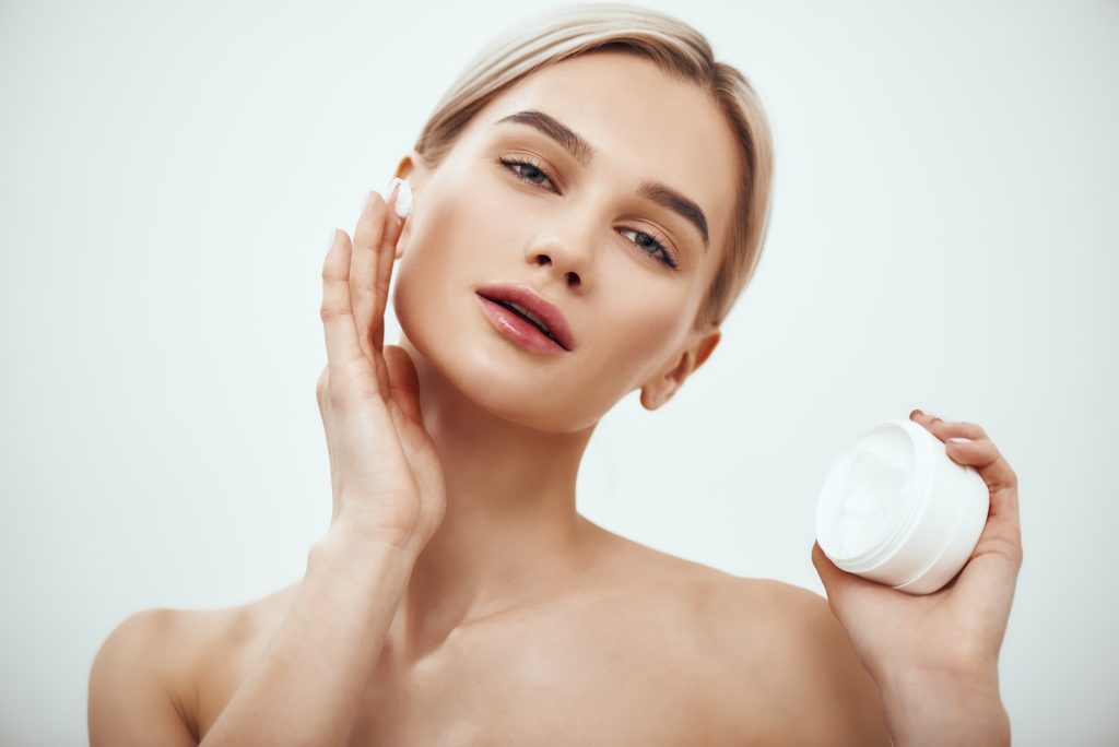 Best moisturizer for your skin type. Portrait of gorgeous young woman spreading cream on her face