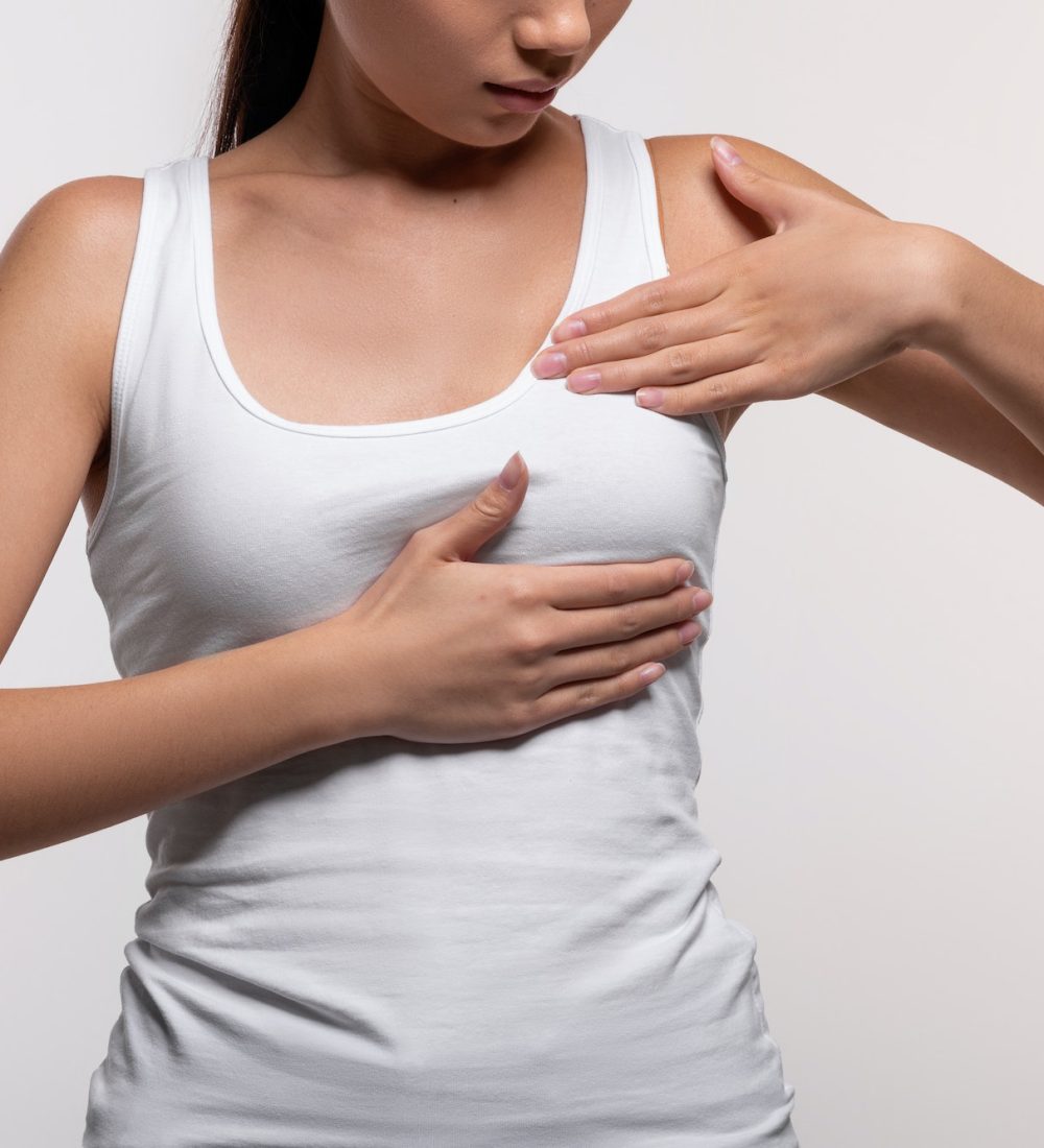 Unrecognizable young woman examining her breasts, closeup